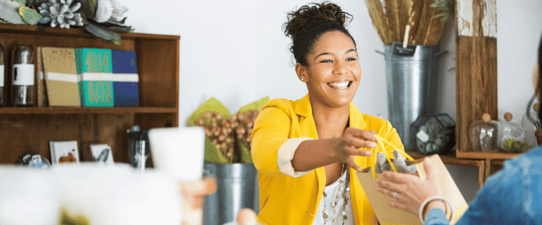 Lead generation for a small business - A woman giving a bag to a customer