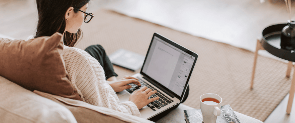 a woman sitting on a couch typing